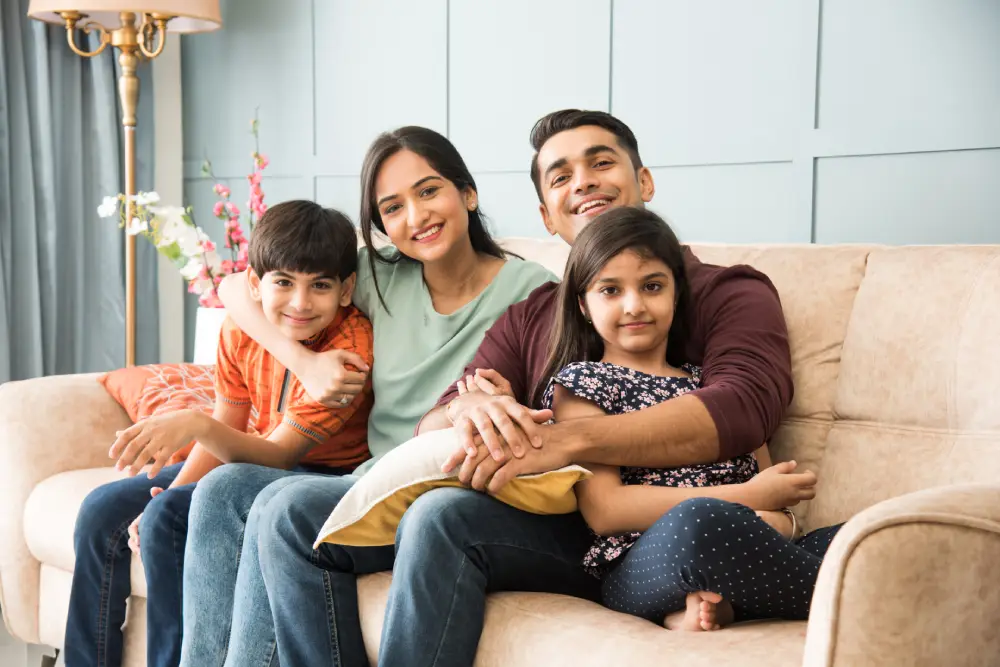 portrait happy Indian Asian young family while sitting sofa lying floor sitting against wall