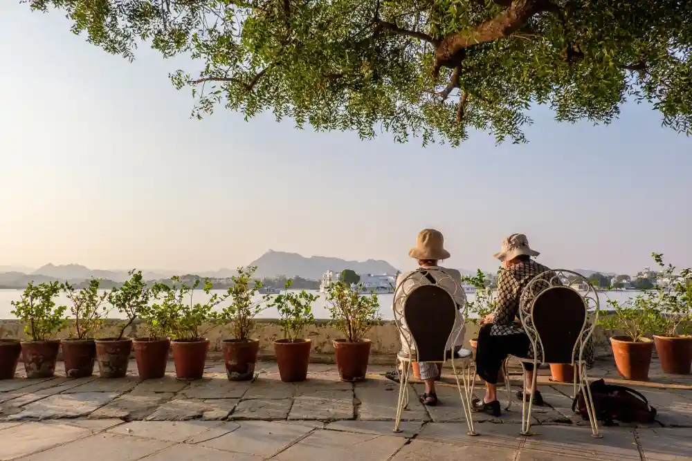Two retirees relaxing by a lake, representing the peace of mind found through community living and strategic relocation.