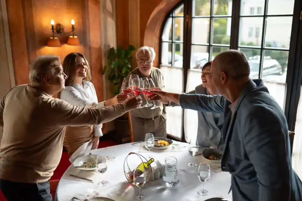 Group of senior friends toasting with wine, enjoying the freedom of downsizing to a small home.